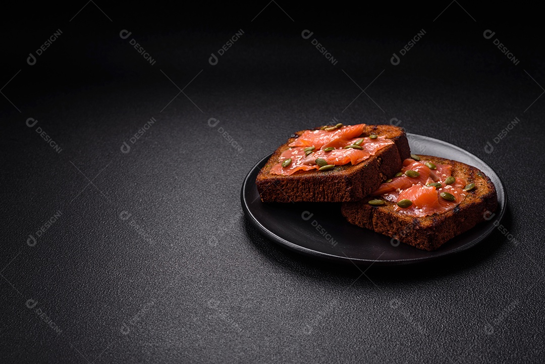 Torradas grelhadas com pasta de abacate, ovos, cream cheese, sal, especiarias e ervas sobre uma mesa de concreto texturizado