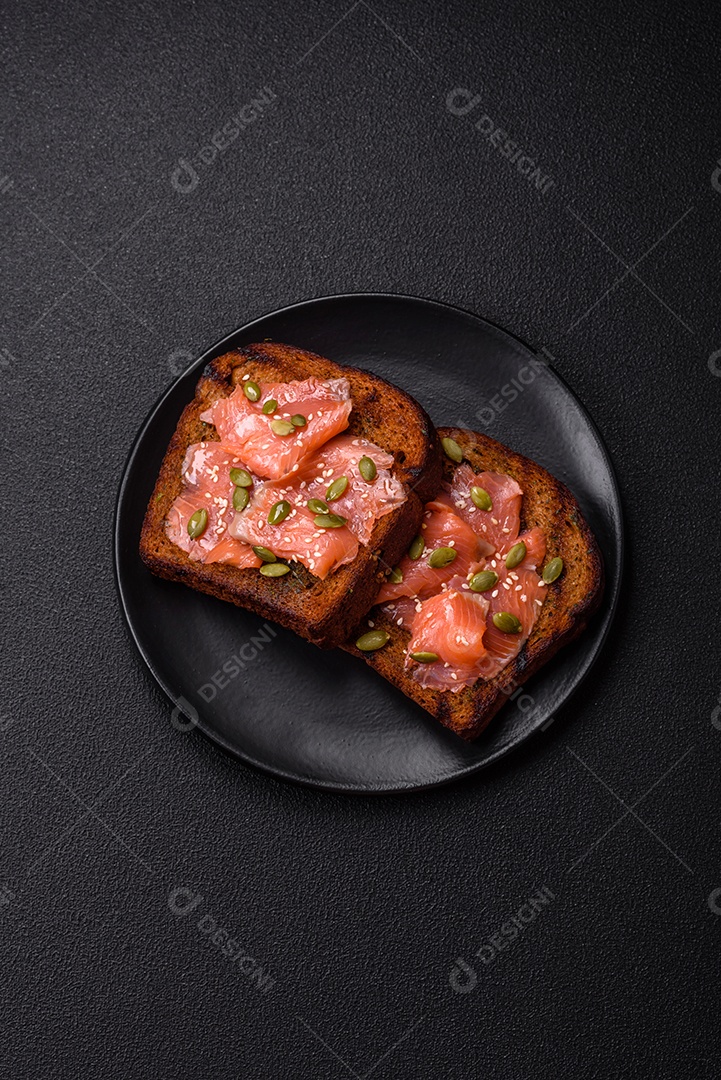 Torradas grelhadas com pasta de abacate, ovos, cream cheese, sal, especiarias e ervas sobre uma mesa de concreto texturizado