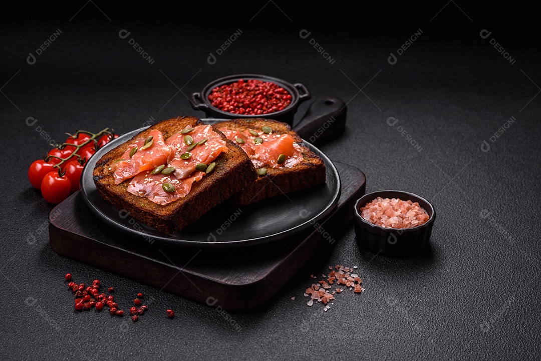 Torradas grelhadas com pasta de abacate, ovos, cream cheese, sal, especiarias e ervas sobre uma mesa de concreto texturizado