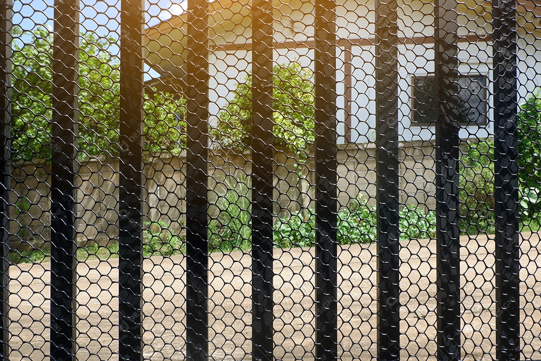 Fixar uma rede plástica em forma de favo de mel no portão