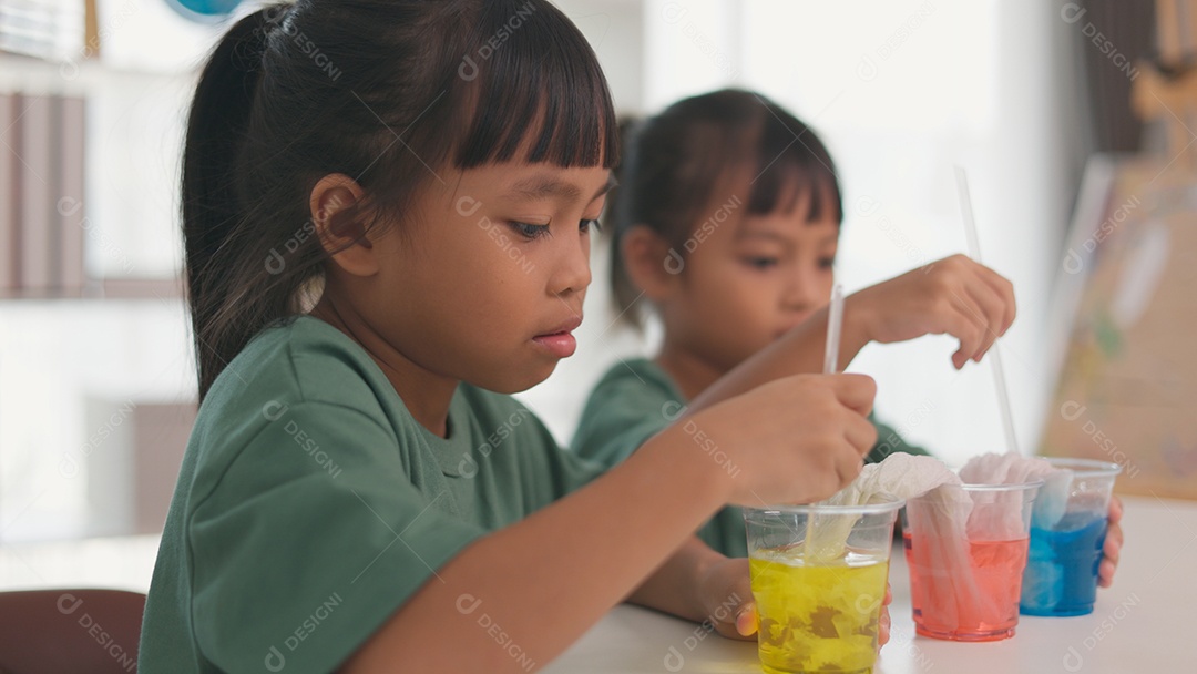 Crianças estão focados no experimento e parecem estar se divertindo
