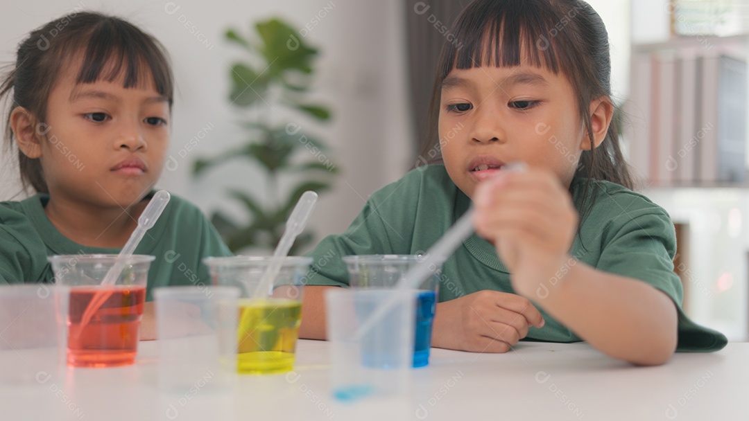 Crianças estão focados no experimento e parecem estar se divertindo