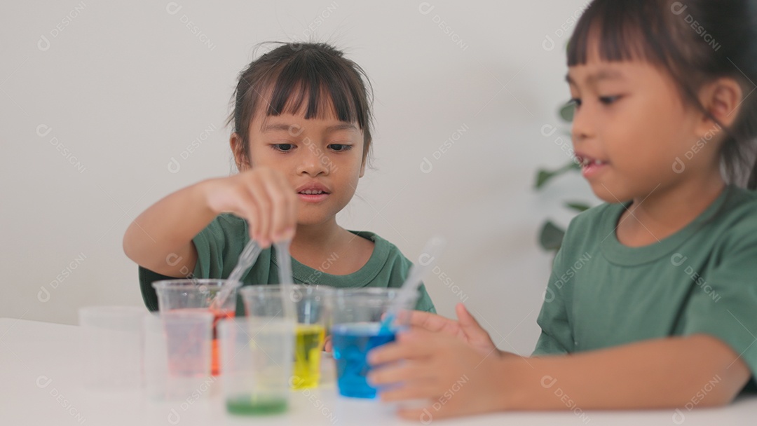 Crianças estão focados no experimento e parecem estar se divertindo