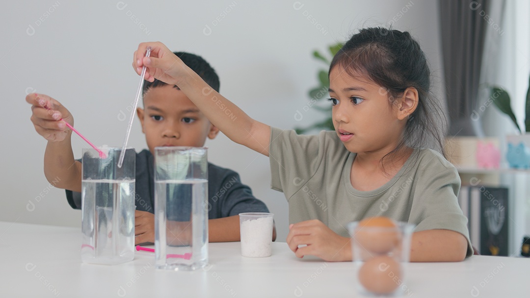 Duas criança fazendo experimento cientifico com água