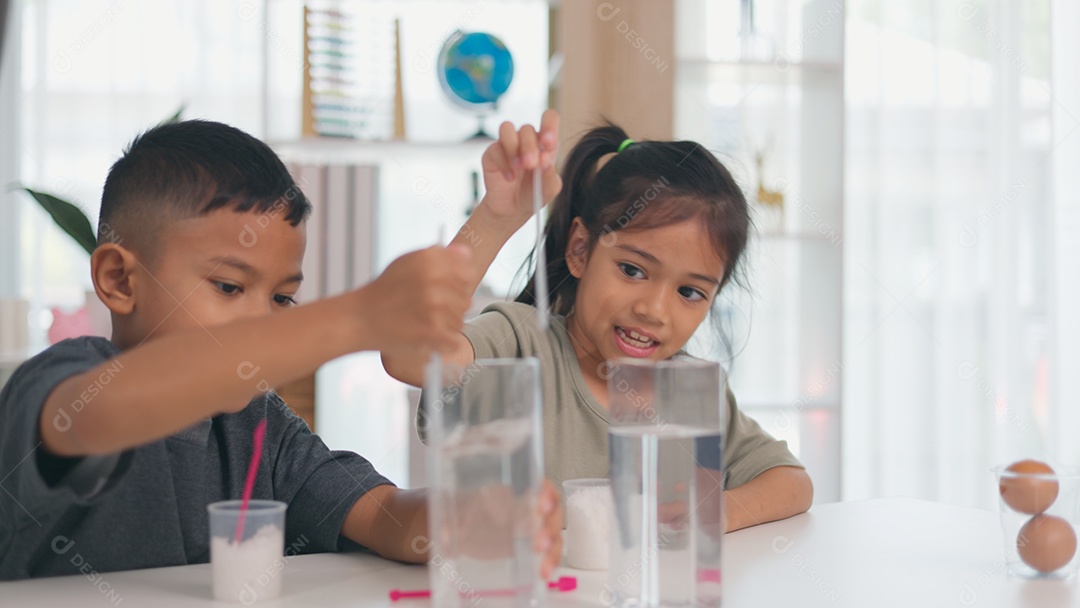 Duas crianças fazendo experimento cientifico com água