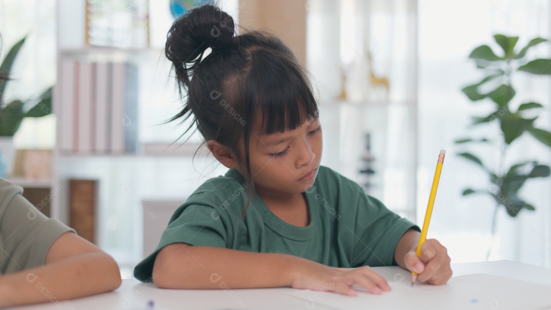 Garotinha linda concentrada em sua tarefa escolar