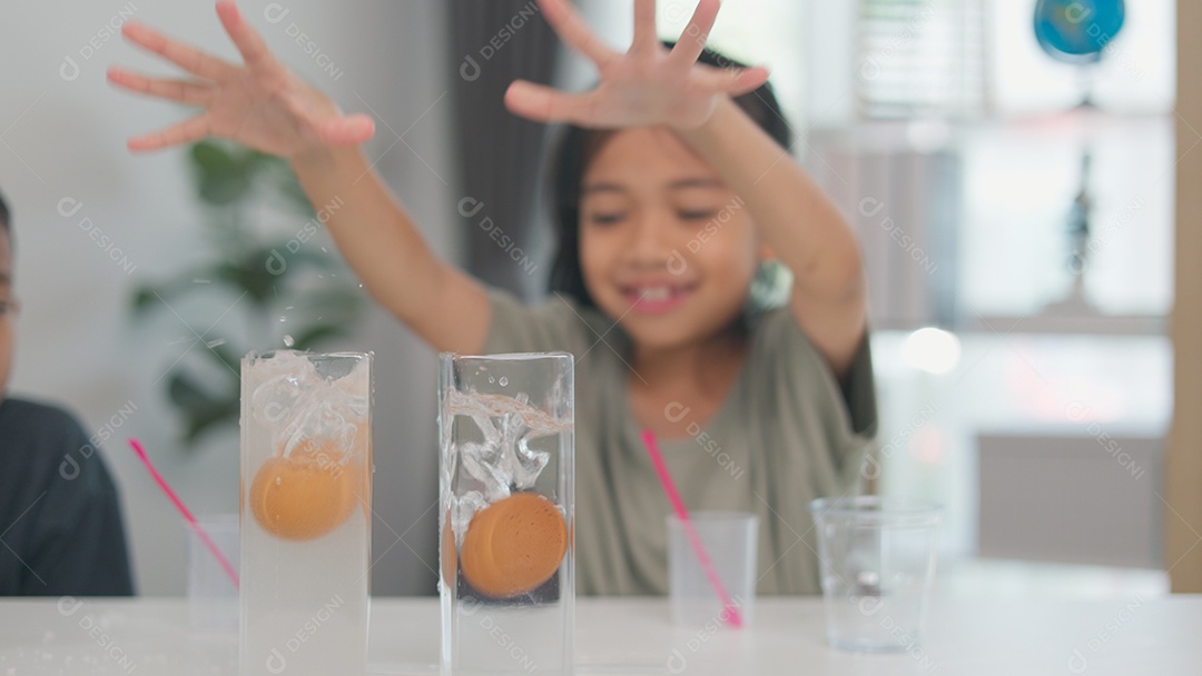 Uma garotinha está brincando com um brinquedo na frente de um menino