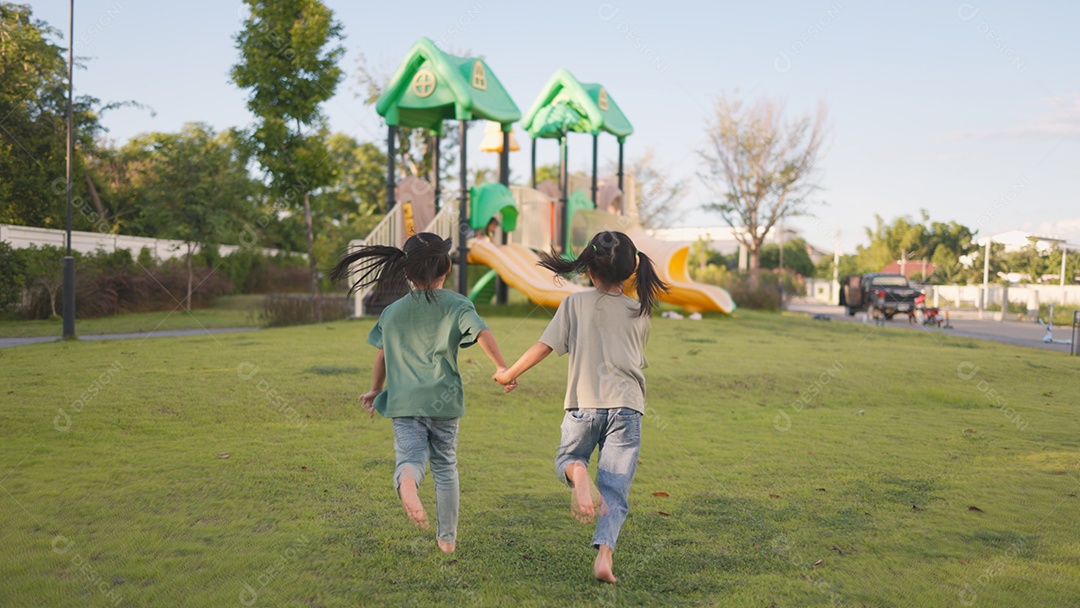 Duas garotinhas correndo em direção ao parquinho