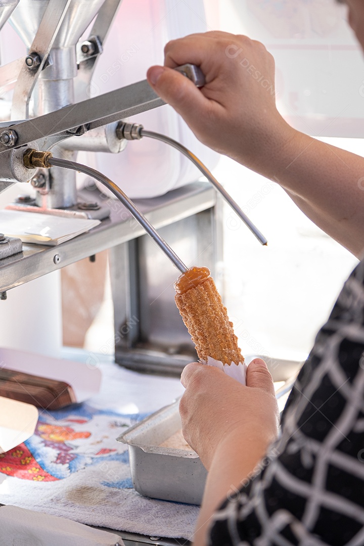 Pessoa colocando recheio dentro do churros