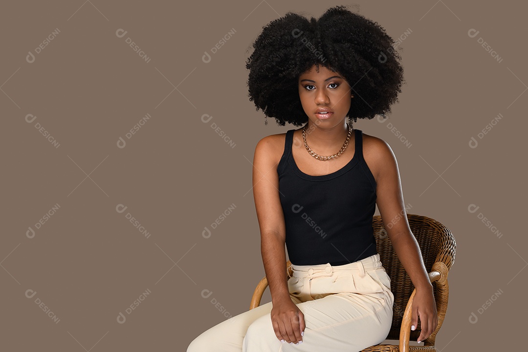 Linda jovem morena com roupas moderna sentada na cadeira