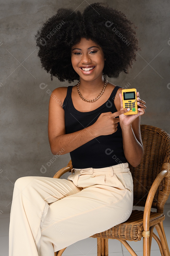 Jovem afro sorrindo segurando uma maquina de cartão