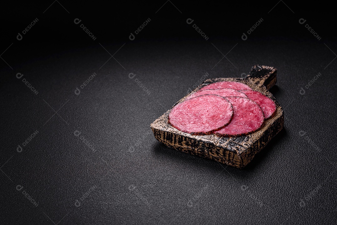 Salame defumado sobre uma tábua de madeira sobre mesa