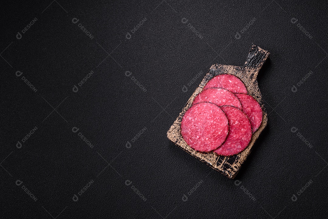 Salame defumado sobre uma tábua de madeira sobre mesa