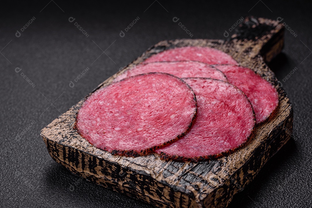 Salame defumado sobre uma tábua de madeira sobre mesa