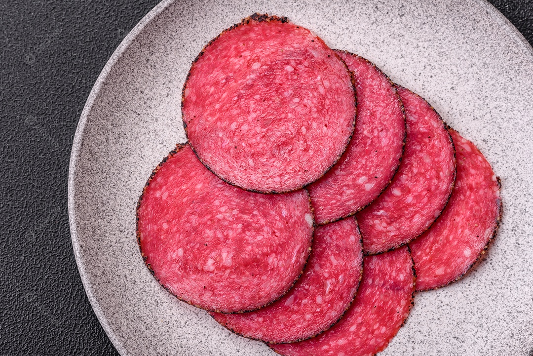 Salame defumado sobre prato de sobre mesa