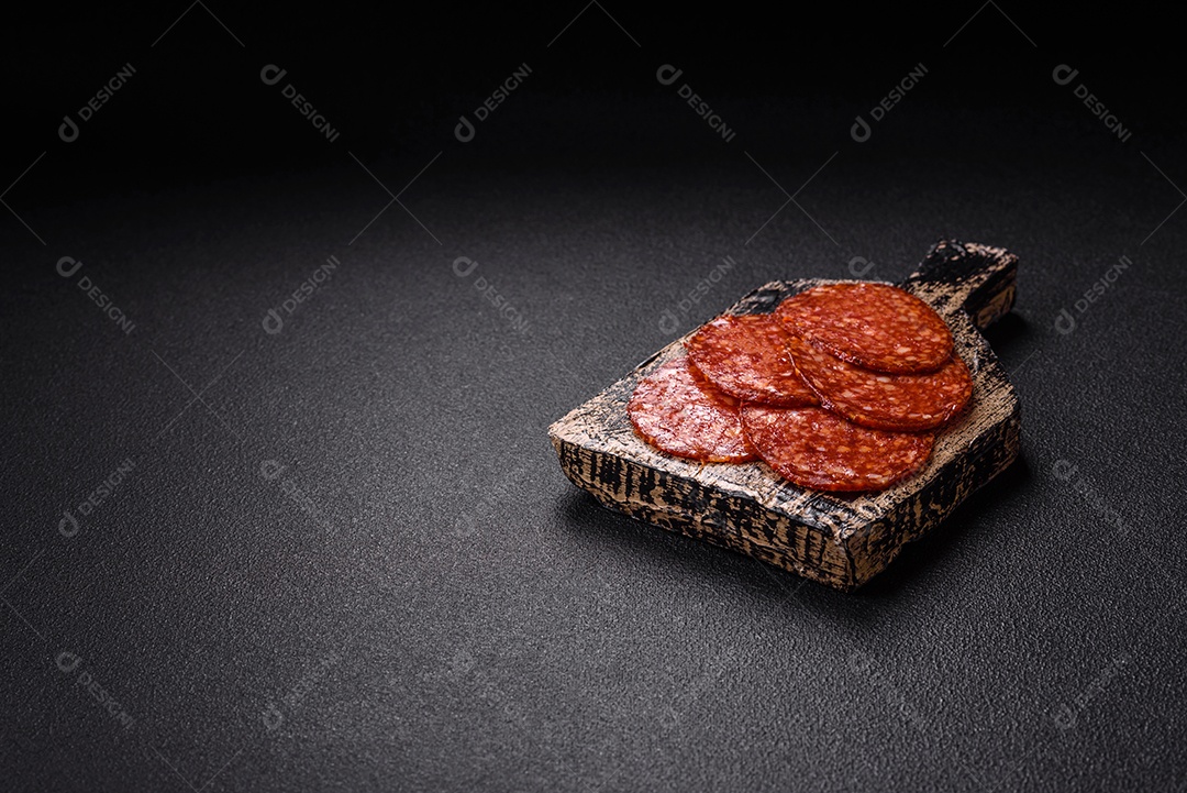 Salame defumado sobre uma tábua de madeira sobre mesa