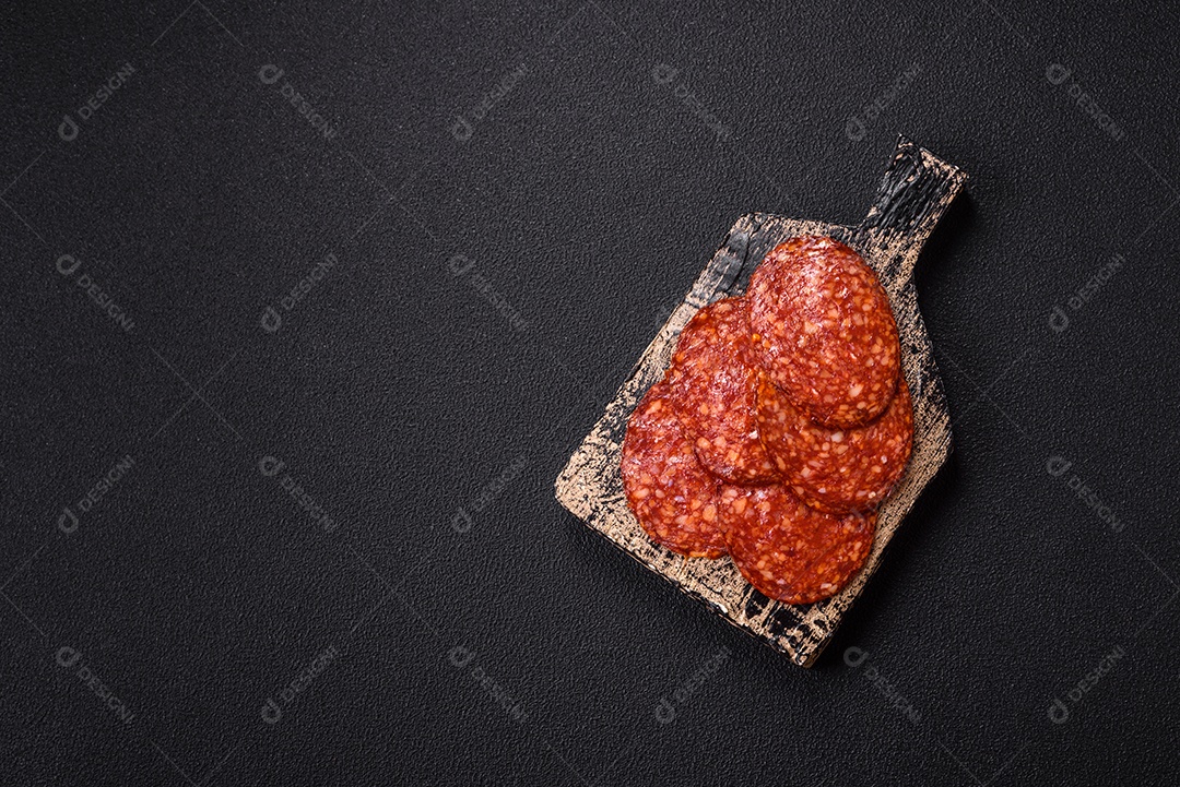 Salame defumado sobre uma tábua de madeira sobre mesa