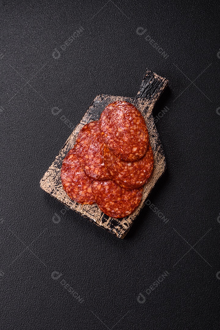Salame defumado sobre uma tábua de madeira sobre mesa