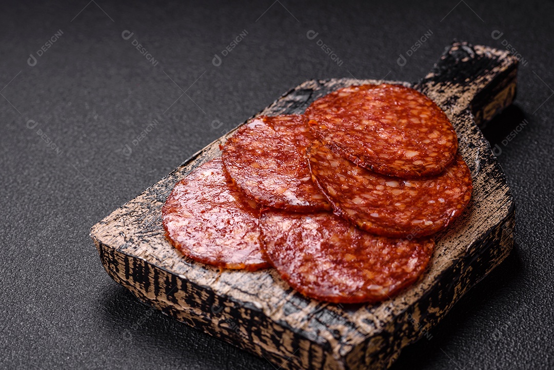 Salame defumado sobre uma tábua de madeira sobre mesa