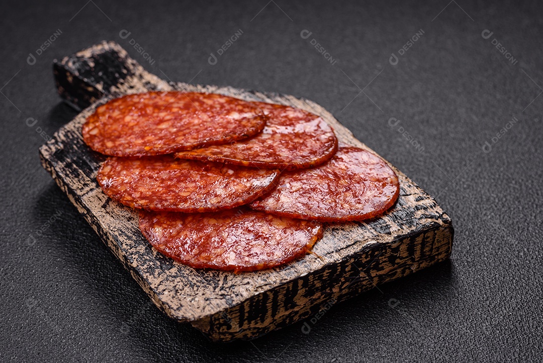 Salame defumado sobre uma tábua de madeira sobre mesa