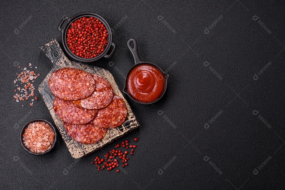 Salame defumado sobre uma tábua de madeira sobre mesa