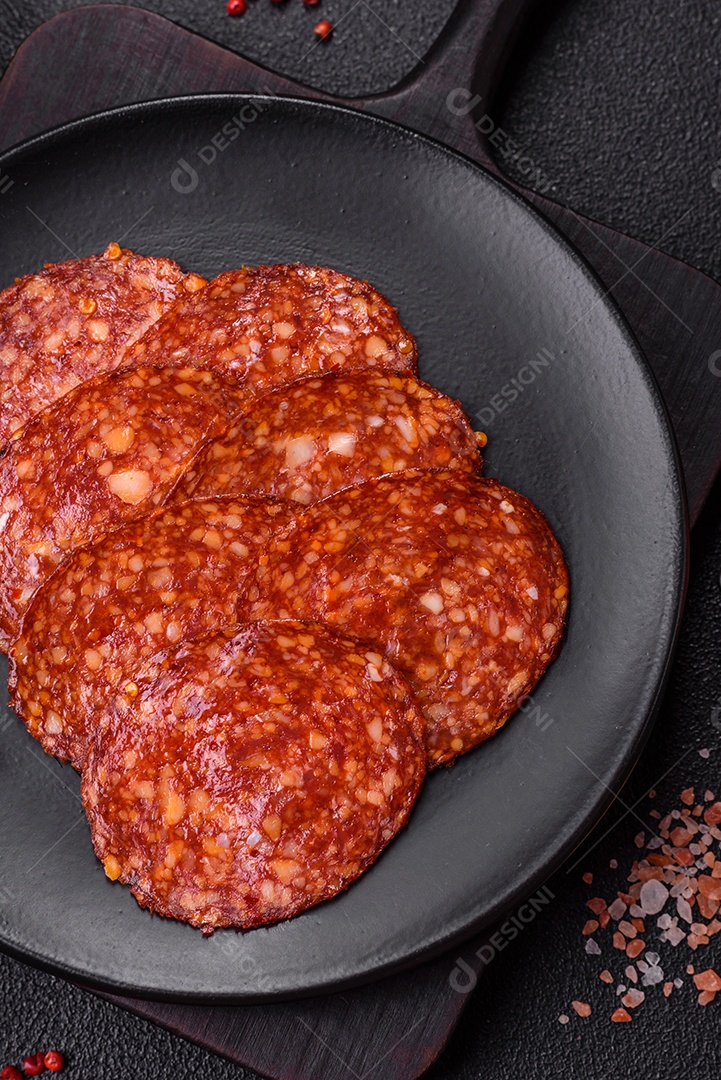 Salame defumado sobre uma tábua de madeira sobre mesa