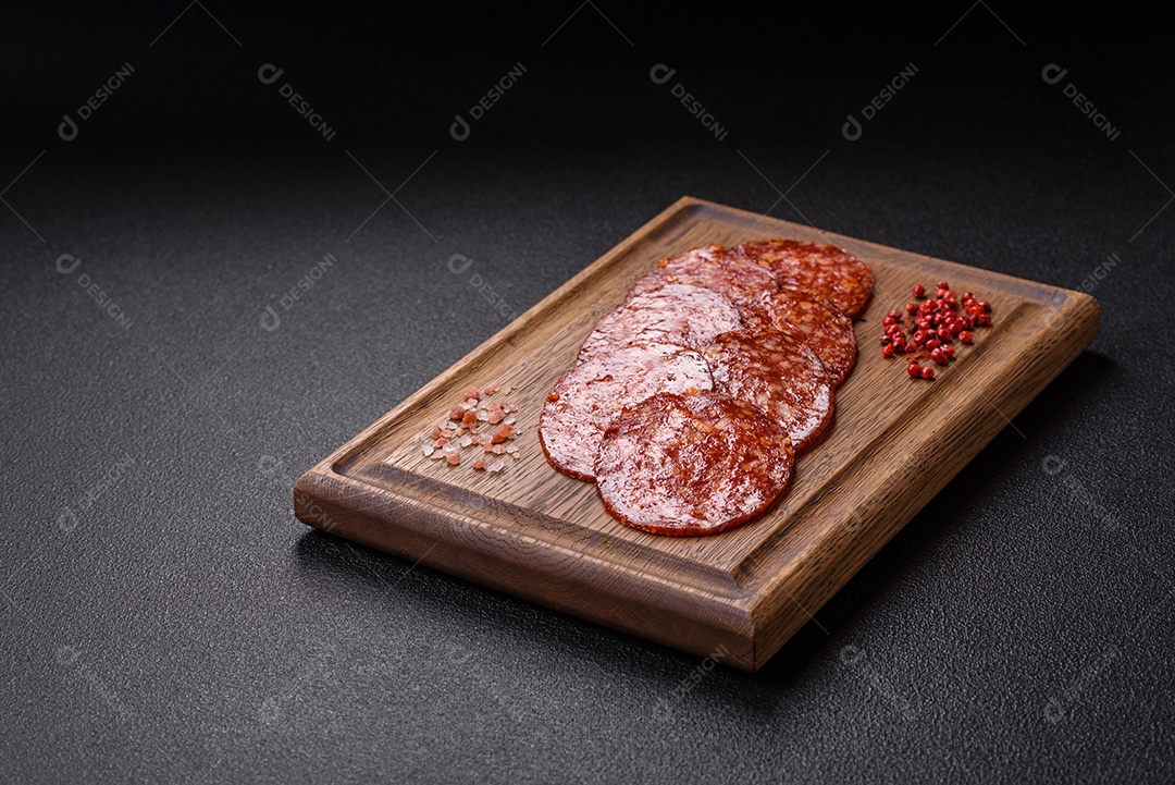 Salame defumado sobre uma tábua de madeira sobre mesa