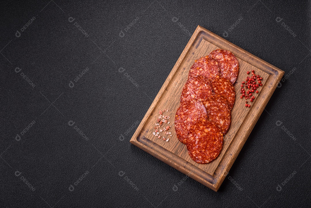 Salame defumado sobre uma tábua de madeira sobre mesa