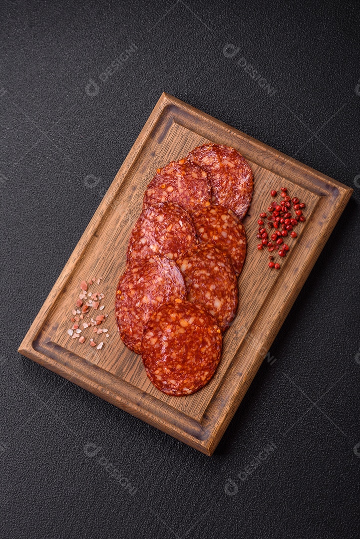 Salame defumado sobre uma tábua de madeira sobre mesa