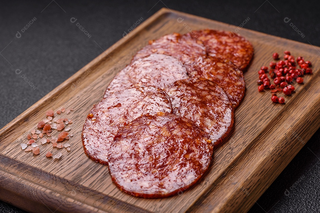 Salame defumado sobre uma tábua de madeira sobre mesa