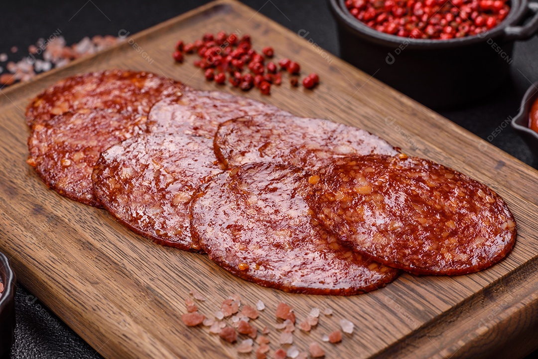 Salame defumado sobre uma tábua de madeira sobre mesa