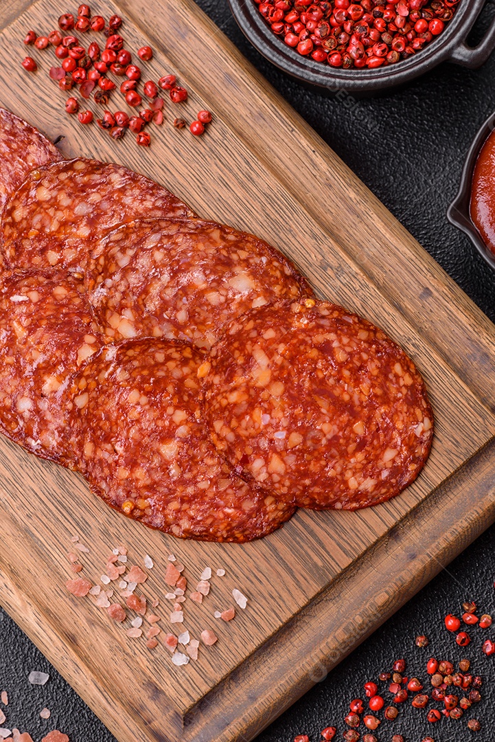 Salame defumado sobre uma tábua de madeira sobre mesa