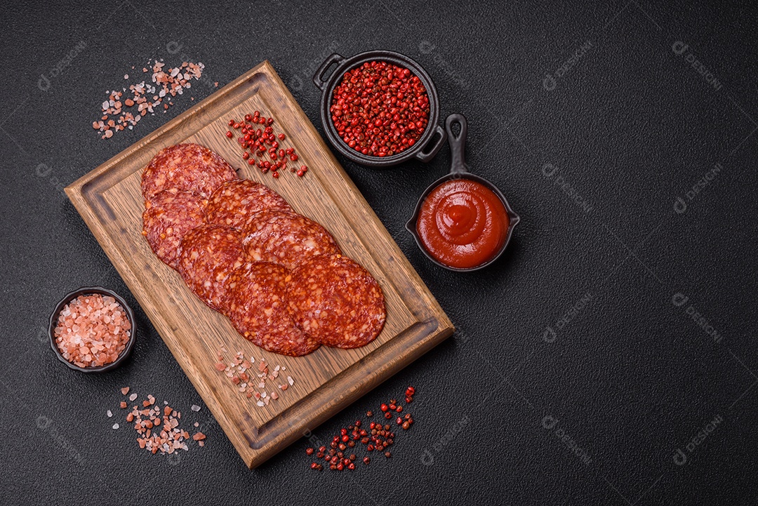 Salame defumado sobre uma tábua de madeira sobre mesa