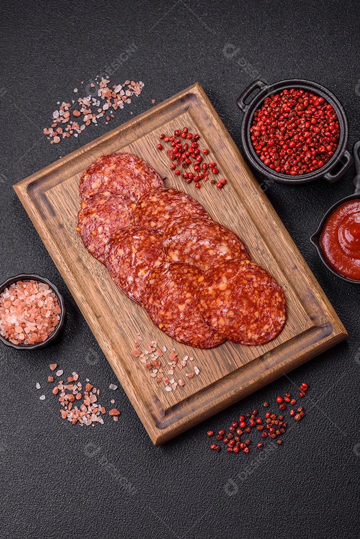Salame defumado sobre uma tábua de madeira sobre mesa