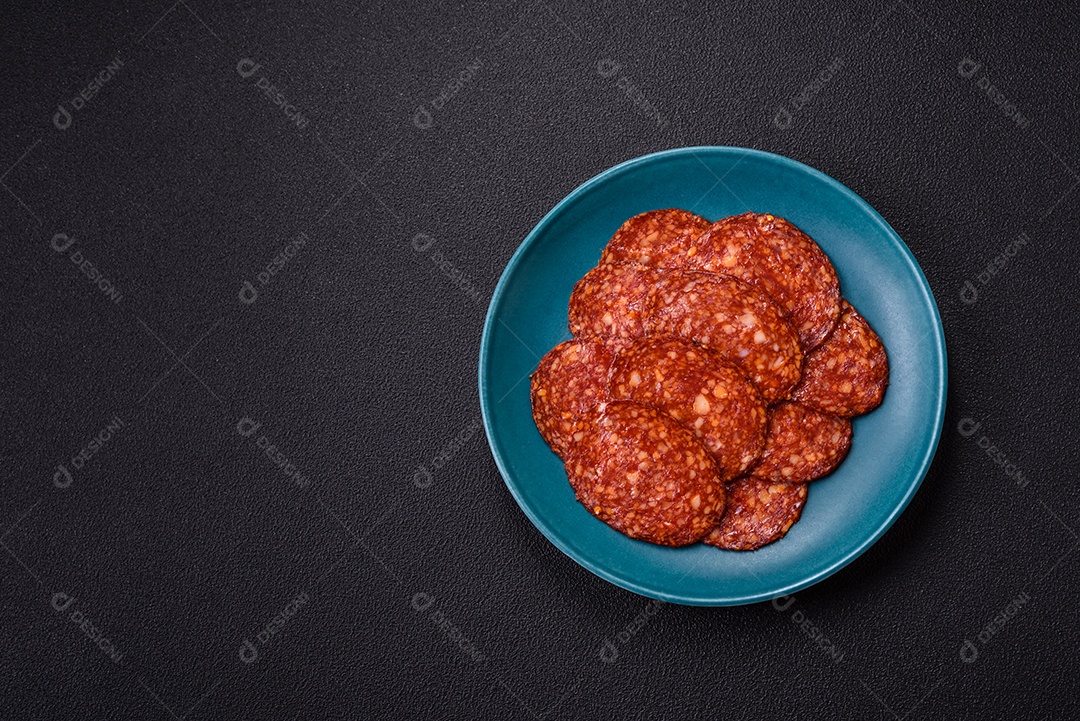 Salame defumado sobre prato em uma mesa de concreto