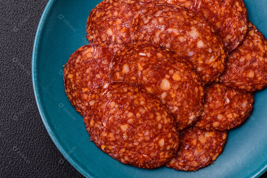 Salame defumado sobre uma tábua de madeira sobre mesa
