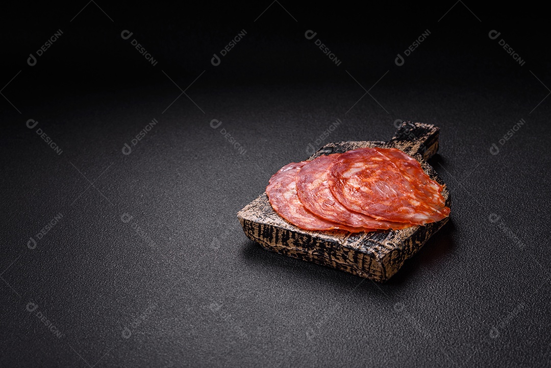 Salame defumado sobre uma tábua de madeira sobre mesa