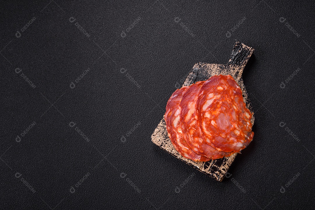 Salame defumado sobre uma tábua de madeira sobre mesa