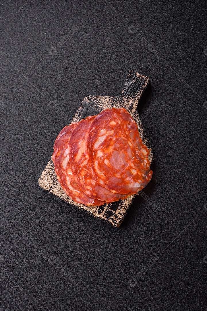 Salame defumado sobre uma tábua de madeira sobre mesa