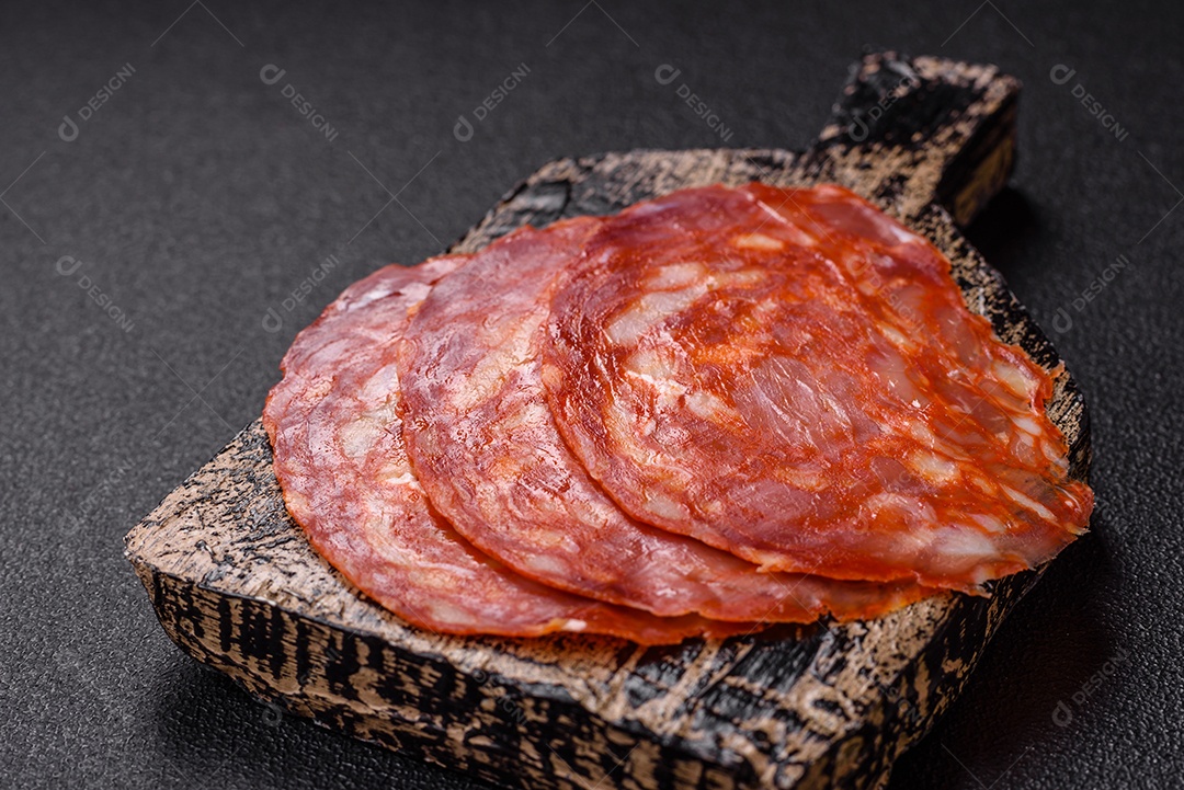 Salame defumado sobre uma tábua de madeira sobre mesa