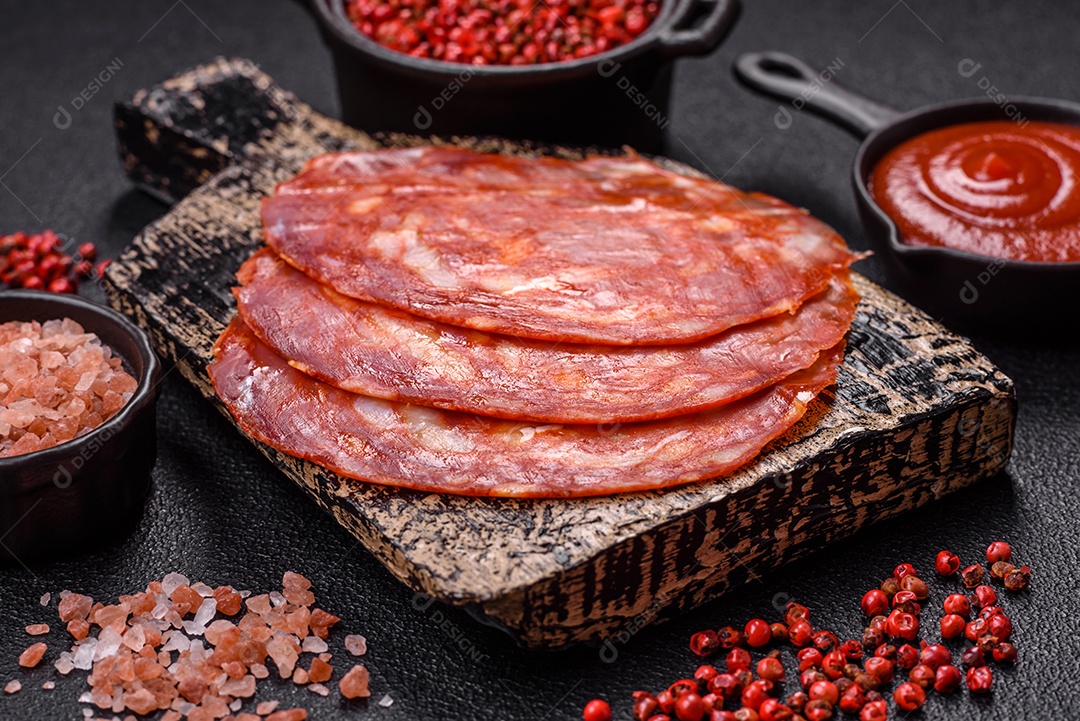 Salame defumado sobre uma tábua de madeira sobre mesa
