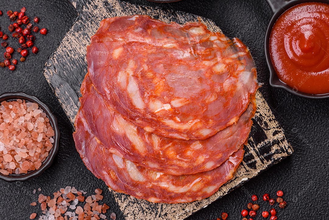 Salame defumado sobre uma tábua de madeira sobre mesa