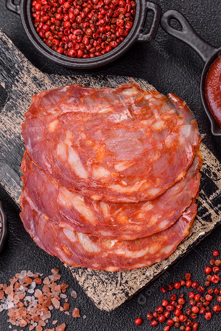 Salame defumado sobre uma tábua de madeira sobre mesa