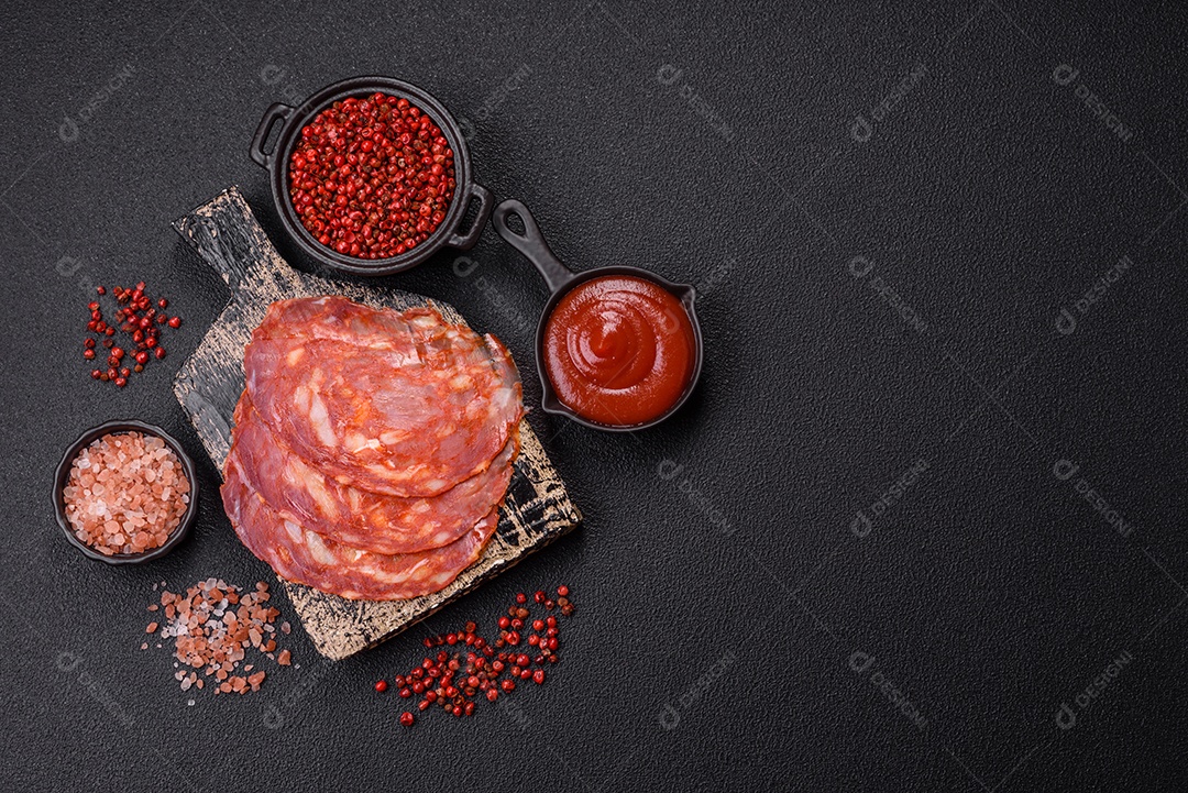 Salame de chouriço sobre tábua de madeira com temperos ao lado