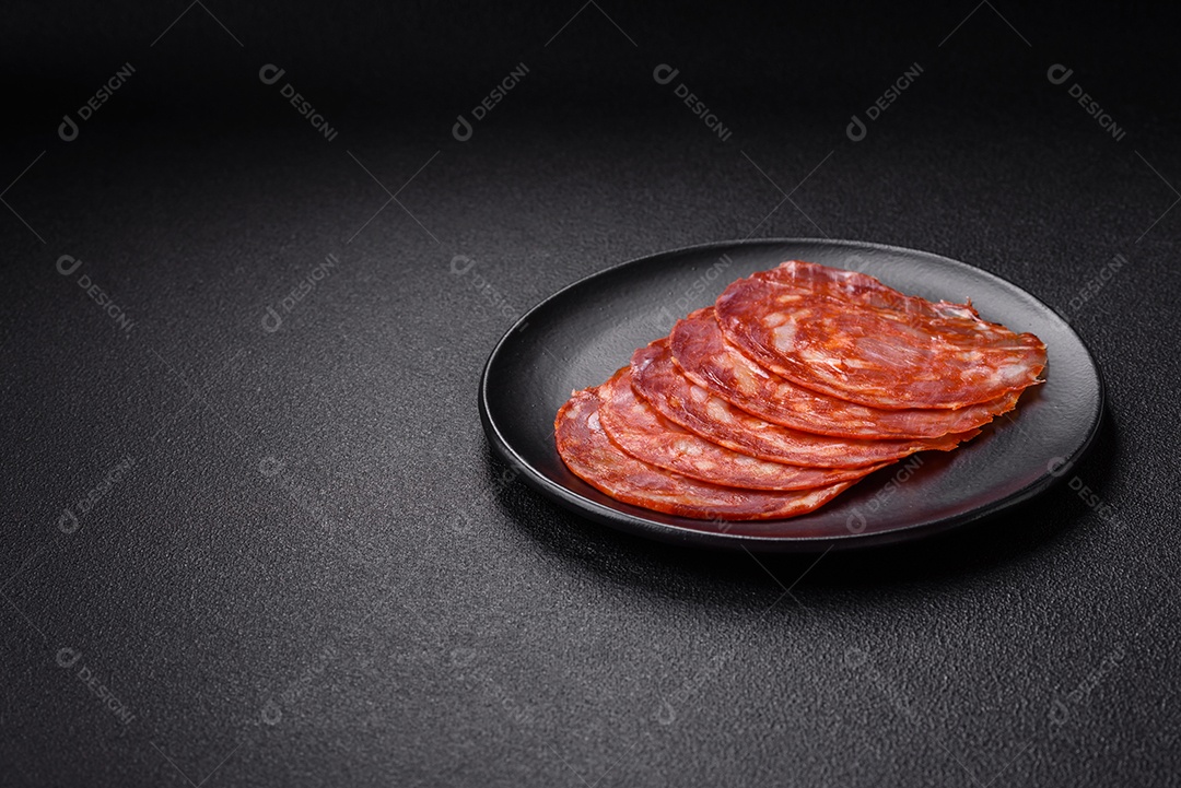 Salames chouriço dentro de frigideira com temperos ao lado