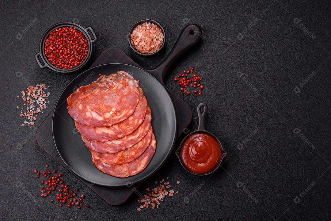 Salames chouriço dentro de frigideira com temperos ao lado