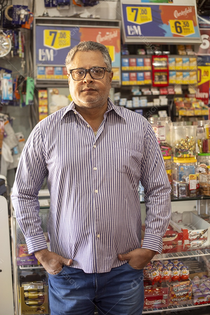 Homem com mãos no bolso na frente de balcão de mercado