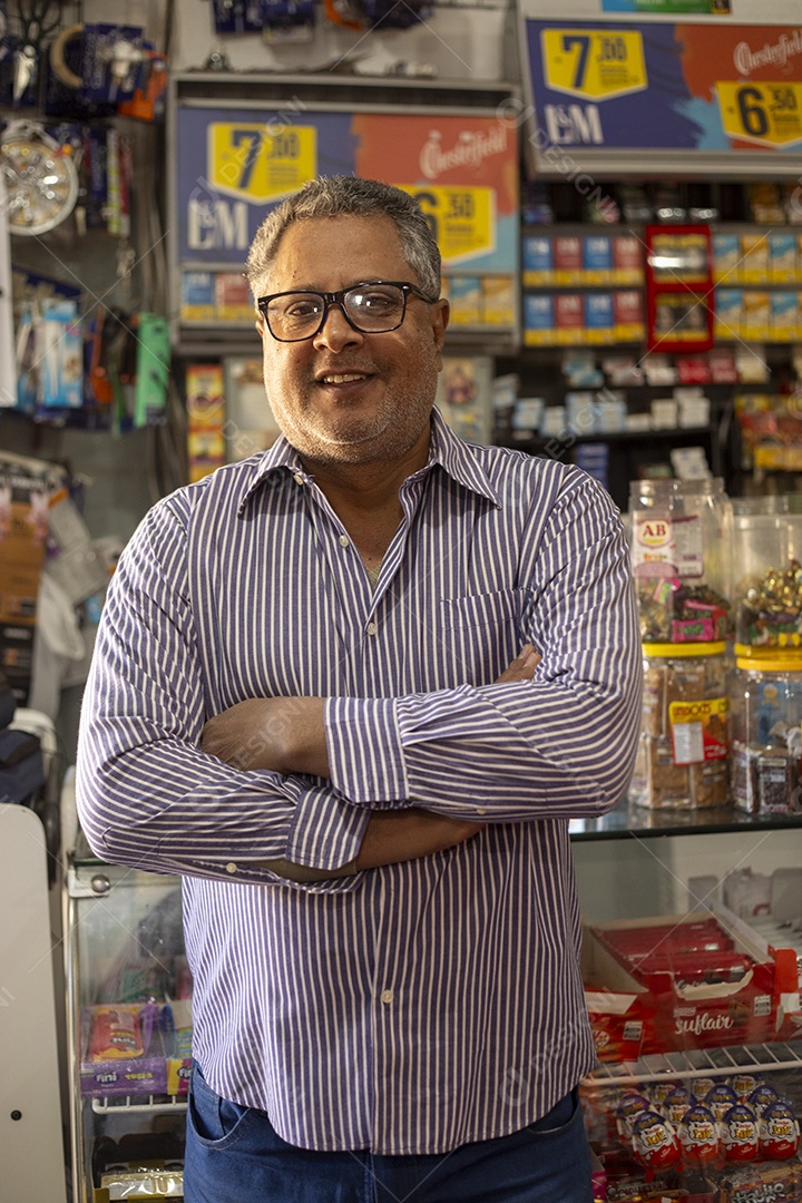 Homem feliz com braços cruzados na frente de balcão