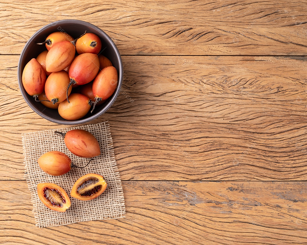 Tamarillos ou tomates de árvore em uma tigela sobre mesa de madeira