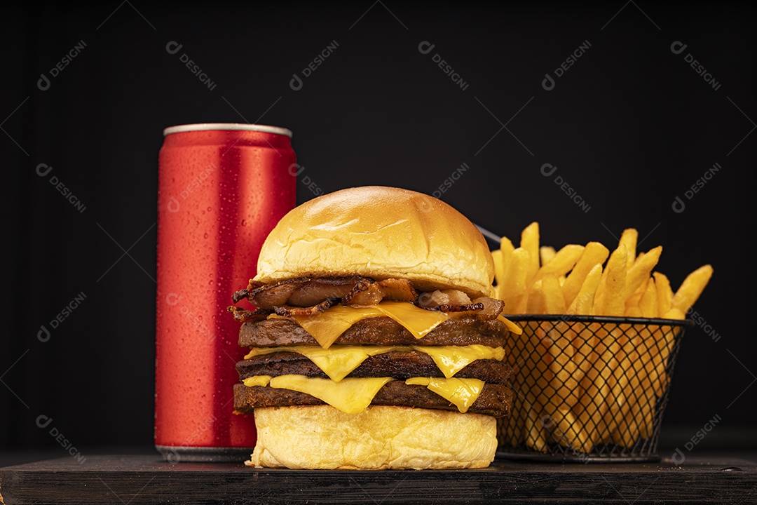 Hamburguer delicioso gigante com batatas ao lado e lata de refrigerante